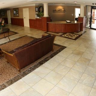 A spacious hotel lobby with a reception desk and seating area.