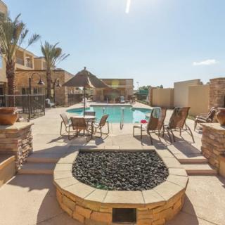 A sunny outdoor patio with a swimming pool and seating area.