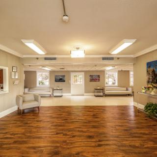 A spacious and well-lit interior room featuring comfortable furniture and wooden flooring.