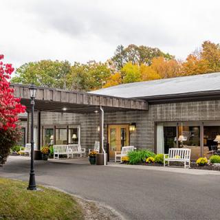 A modern building surrounded by autumn foliage and well-maintained landscaping.