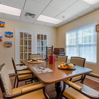 A cozy dining room with a wooden table, chairs, and bright natural light.