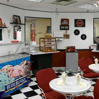 A retro-style ice cream shop with a checkerboard floor and vintage decorations.