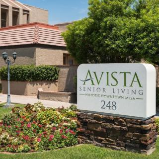 A senior living facility with a well-maintained garden and sign displaying 'Avista Senior Living'.