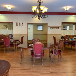 A cozy dining room with elegant furniture and a chandelier.