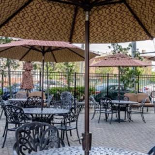 A tranquil outdoor seating area with tables and umbrellas, perfect for enjoying a meal or drink in the fresh air.