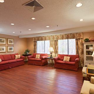A cozy living room with red sofas and warm lighting.