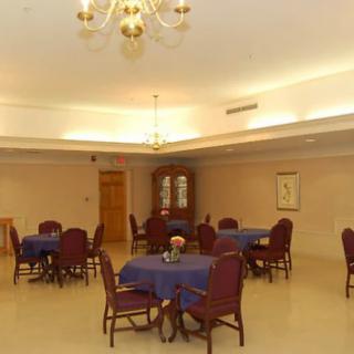 A well-lit dining room with multiple tables and chairs set up for guests.