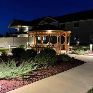 Illuminated gazebo and garden pathway at night.