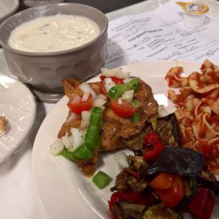 A delicious meal featuring a bowl of soup, pasta, and a variety of vegetables.