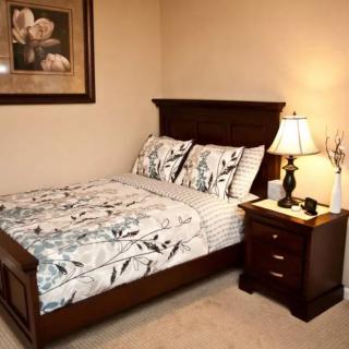 A cozy bedroom with a neatly made bed, nightstand, and decorative elements.