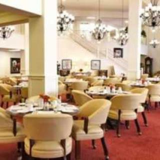 An elegant restaurant dining area with neatly arranged tables and chairs, adorned with chandeliers.