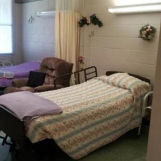 A hospital room with a patient bed and recliner chair.