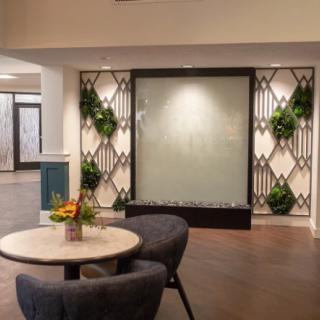 A modern lobby area with stylish furniture and decorative plants on the wall.
