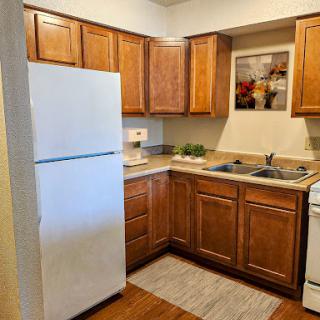A cozy kitchen featuring wooden cabinets and essential appliances.