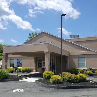 A modern building with well-maintained landscaping under a clear blue sky.