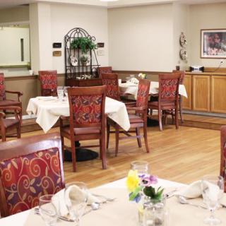 An elegantly set dining area with tables and chairs, featuring decorative elements and floral centerpieces.