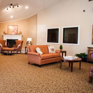 A cozy living room with sofas, a fireplace, and coffee tables.