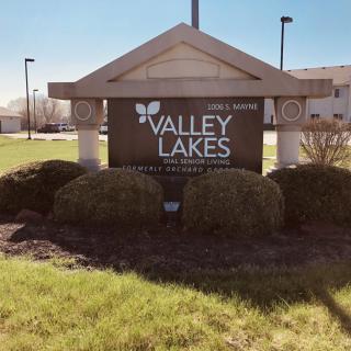 Entrance sign for Valley Lakes surrounded by greenery.