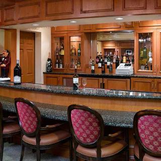 A cozy bar interior with a granite counter and upholstered chairs.