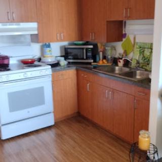 A cozy kitchen equipped with essential appliances and wooden cabinetry.