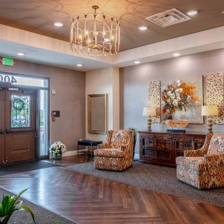 A cozy lobby with elegant decor, featuring a chandelier and comfortable seating.