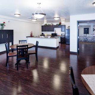 A modern kitchen and dining area with wood flooring and sleek cabinetry.