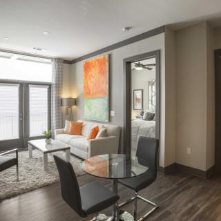 A modern and cozy living room in an apartment featuring stylish furniture and vibrant artwork.