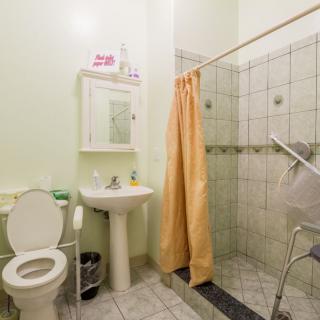 A well-maintained bathroom featuring a toilet, sink, and shower with a yellow curtain.