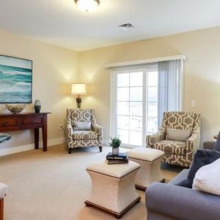 A cozy living room with comfortable seating and natural light streaming in from large windows.