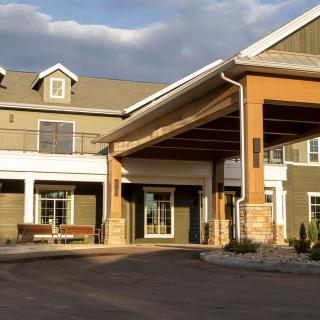 A sunny exterior view of a residential building entrance.