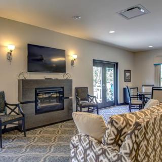 A cozy living room with a fireplace and television, featuring comfortable seating and elegant lighting.