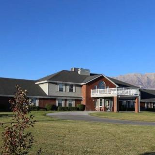 A large house with a spacious lawn against a clear blue sky.