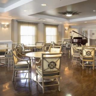Elegant dining room with a grand piano and hardwood flooring.