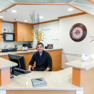 A reception area featuring a friendly employee at the front desk, ready to assist visitors.