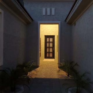 A well-lit entrance pathway leading to a front door at night.