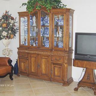 A living room featuring a wooden cabinet and television stand with traditional decor.