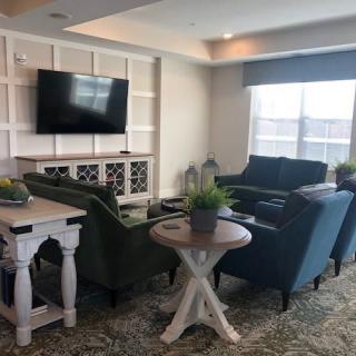 A cozy living room setup with sofas, a coffee table, a television, and decorative plants.