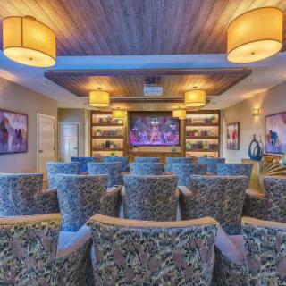 A cozy home theater with plush seating and warm lighting, featuring a large screen for an immersive viewing experience.