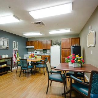A communal kitchen and dining area with tables, chairs, and appliances.