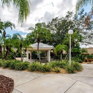 A charming gazebo surrounded by lush tropical plants and palm trees.