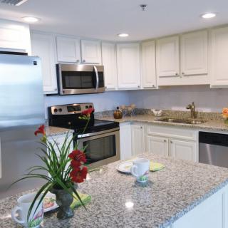 A modern kitchen with granite countertops and stainless steel appliances.