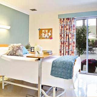 A bright and inviting hospital patient room with comfortable furnishings and natural light.