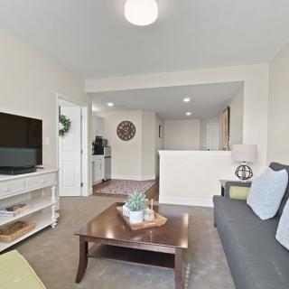 A cozy living room with a sofa, coffee table, and television.