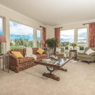 A cozy living room with large windows, comfortable seating, and tasteful decor.