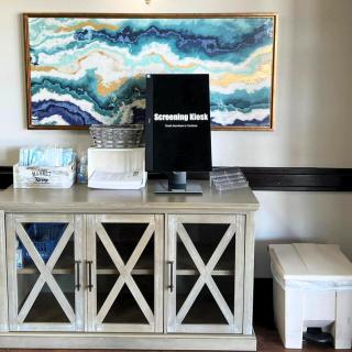 A stylish interior featuring a decorative cabinet with an abstract artwork above.