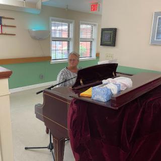 A person playing the piano in a cozy community space.