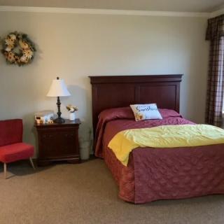 A cozy bedroom with a neatly made bed, nightstand, and decorative items.