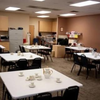 A break room with tables and chairs set up for coffee.