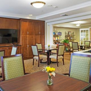 A well-furnished dining area with wooden cabinets, tables, and chairs.