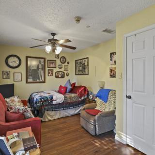 A cozy living room with a couch, chair, and various decorations on the walls.
